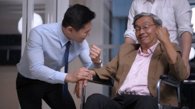 Sağlık konsepti. Genç erkekler ofiste yaşlı insanları teşvik.