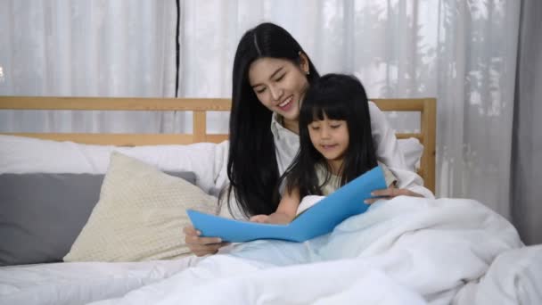 Familieconcept. De moeder vertelt het verhaal aan haar dochter voordat ze slaapt. — Stockvideo