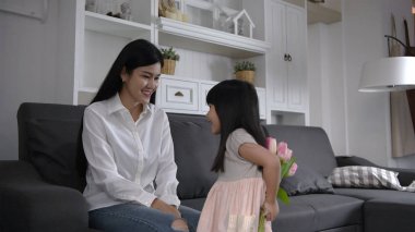 Aile konsepti. Kızı anneye çiçekleri verdi.
