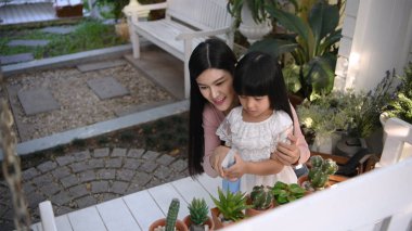 Tatil konsepti. Anne kızına ağaç dikmelerini öğretiyor. 