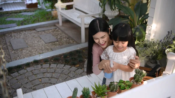 Concepto de vacaciones. Mamá está enseñando a su hija a plantar árboles — Foto de Stock