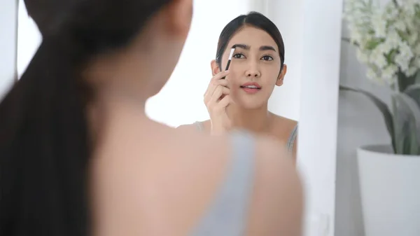 Skönhetskoncept. Reflektioner i spegeln Asiatiska tjejer är makeup — Stockfoto