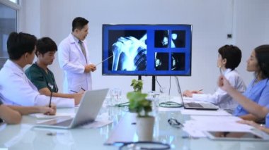 Tıbbi konsept. Doktor monitördeki omuz kaslarını röntgenini açıklıyor. 4k Çözünürlük.