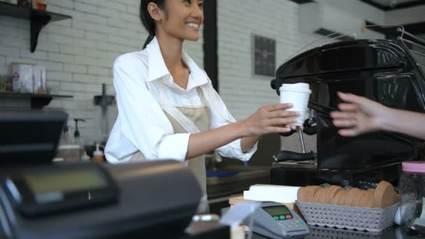コーヒーショップのコンセプト 少女は 顧客が支払い機を通じて支払うことを示唆しています 4K解像度 — ストック動画