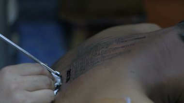 Dövme kavramları. Sanatçı sivri bir metal ile cilt üzerinde bir Tay tarzı desen dövme olduğunu. 4k Çözünürlük.