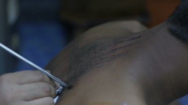 Dövme kavramları. Sanatçı sivri bir metal ile cilt üzerinde bir Tay tarzı desen dövme olduğunu. 4k Çözünürlük.