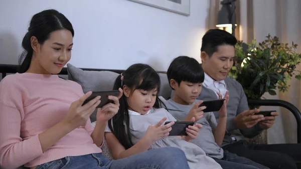 Семейная концепция. Семьи, играющие на мобильных телефонах без оплаты atte — стоковое фото