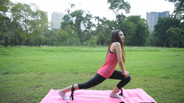 Exercise concepts. A beautiful woman exercising in the park. 4k