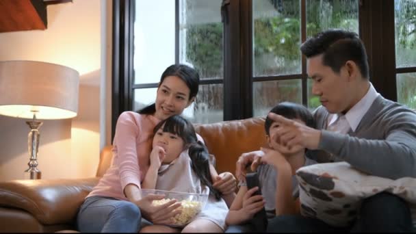 Concept de vacances. La famille regarde la télé joyeusement. Résolution 4k . — Video