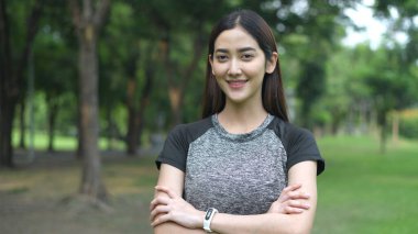 Egzersiz konsepti. Kadın bahçede kendine güvenerek gülümsedi. 4k Çözünürlüğü.