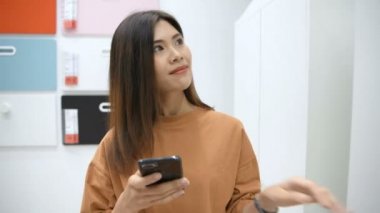 Alışveriş konsepti. Asyalı bir kadın interneti alışveriş merkezindeki ürünleri aramak için kullanıyor. 4k Çözünürlüğü.