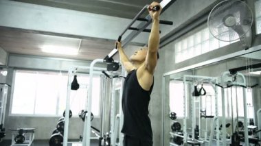 Egzersiz kavramları. Asyalı erkekler sırt kaslarını bir çubukla çalıştırıyorlar. 4k Çözünürlüğü.