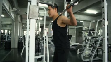 Egzersiz kavramları. Genç erkekler spor salonunda çömelme egzersizleri yaparlar. 4k Çözünürlüğü.