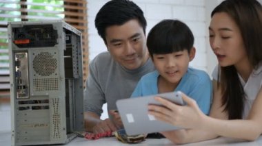 Öğrenme kavramları. Ebeveynler çocuklarını bilgisayar tamir etmeyi öğrenmeleri için teşvik ediyorlar. 4k Çözünürlüğü.