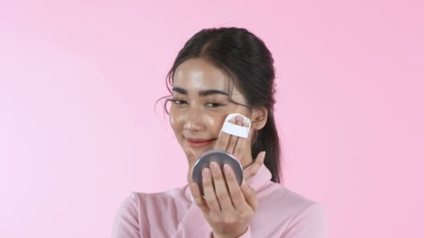 美丽的概念 一个亚洲女人正在粉红的背景上化妆 4K分辨率 — 图库视频影像