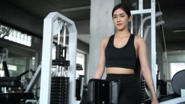 Fitness konsepti. Asyalı bir kadın spor salonunda kalçalarını çalıştırıyor. 4k Çözünürlüğü.