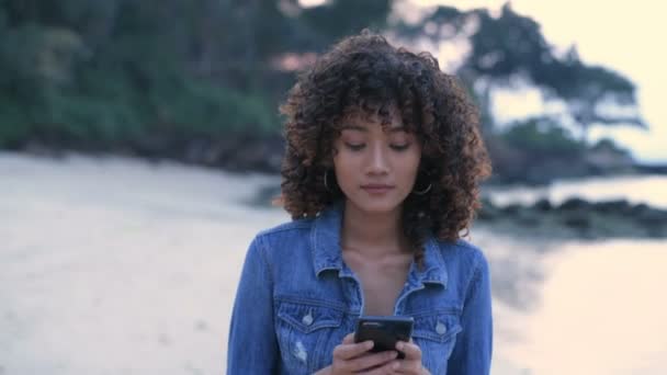 假期的概念 年轻女人喜欢在海滩上玩手机游戏 4K分辨率 — 图库视频影像
