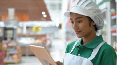 Alışveriş kavramları. Genç kadın alışveriş merkezinin içinde bir tablet kullanarak çalışıyor. 4k Çözünürlüğü.