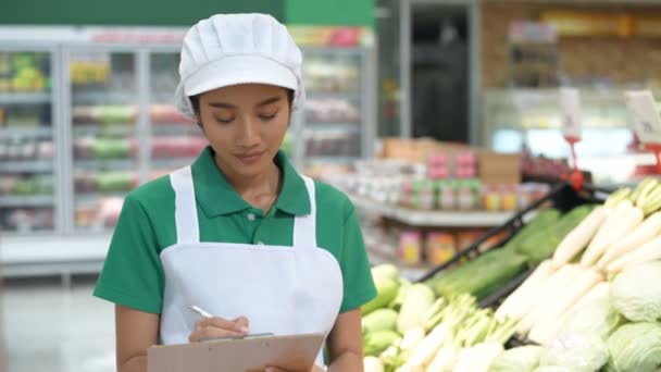 Einkaufskonzepte. Die Frau kontrolliert die Qualität der Produkte in der Obst- und Gemüseabteilung. 4k-Auflösung.