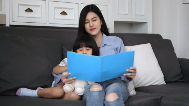 家庭概念 母亲和女儿正在客厅里一起看书 4K分辨率 — 图库视频影像