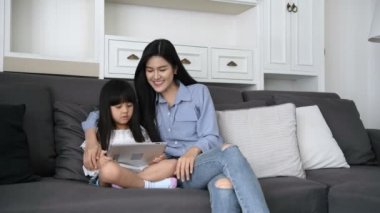 Aile kavramı. Anne ve kızı evde birlikte oyun oynuyorlar. 4k Çözünürlüğü.