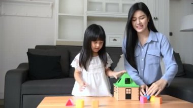 Aile kavramı. Anne ve kızı oturma odasında birlikte aktiviteler yapıyorlar. 4k Çözünürlüğü.