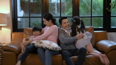 Aile kavramı. Çocuklar oturma odasında ebeveynlerine doğru koşuyorlar. 4k Çözünürlüğü.