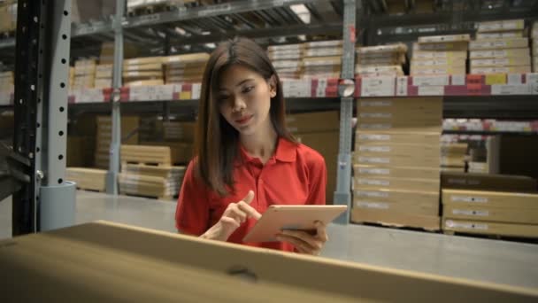 ビジネスの概念 アジアの女性が近代的な技術で倉庫内の製品をチェックしています 4K分解能 — ストック動画