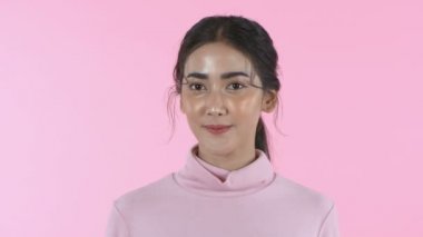Güzellik konsepti. Kadınlar jestler yapıyor. Pembe arka planda yüksek ses kullanmayın. 4k Çözünürlüğü.