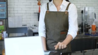 Kahve dükkanı konsepti. Asyalı bir kadın tezgahta parasını alıyor. 4k Çözünürlüğü.