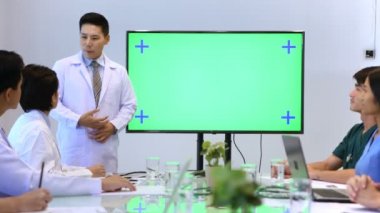 Tıbbi konsept. Doktor toplantıyı yeşil ekranda izleyerek açıklıyor. 4k Çözünürlüğü.