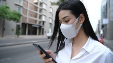 Kirliliği önleme kavramı. Yol kenarında cep telefonuyla oynayan bir kadın. 4k Çözünürlüğü.