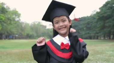 Eğitici kavramlar. Asyalı bir kız bahçede neşeyle dans ediyor. 4k Çözünürlüğü.