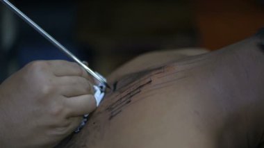 Dövme kavramları. Dövmeci ofiste çalışıyor. 4k Çözünürlüğü.