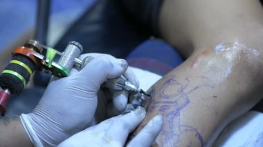 Dövme kavramları. Dövmeci ofiste çalışıyor. 4k Çözünürlüğü.