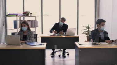 İş kavramları. İş adamları ofiste çalışmak için maske takarlar. 4k Çözünürlüğü.