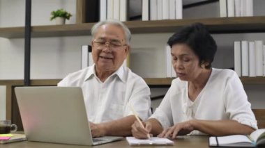 Aile kavramı. İnternetten birlikte çalışan yaşlı bir çift. 4k Çözünürlüğü.