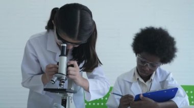 Eğitim konsepti. Çocuk laboratuvar verilerini kaydediyor. 4k Çözünürlüğü.