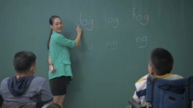 Eğitim konsepti. Öğretmen sınıfta engelli çocuklara heceleme kelimeleri öğretiyor. 4k Çözünürlüğü.