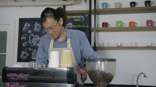 Barista-konceptet. En asiatisk manlig anställd som städar butiken. 4k Upplösning. — Stockvideo