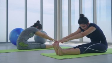 Egzersiz konsepti. Tepeden tırnağa kadınlar fitness stüdyosunda yoga sınıfında poz veriyorlar. 4k Çözünürlüğü.