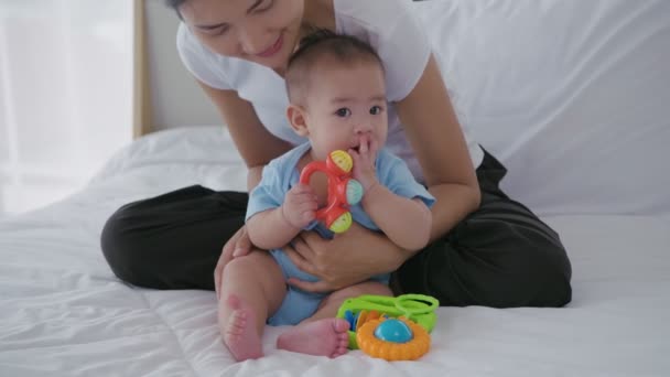家族の概念 赤ちゃんがおもちゃで遊んでいるのを見ているお母さん 4K分解能 — ストック動画
