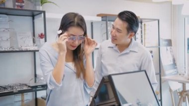 Optik dükkan konsepti. Bir çift mağazadan bardak alıyor. 4k Çözünürlüğü.