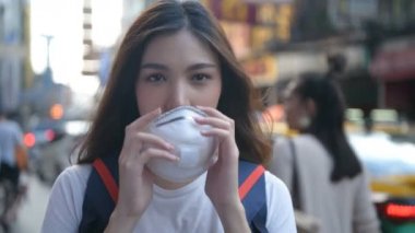 Kirliliği önleme kavramı. Şehrin sokaklarında maske takan güzel bir kadın. 4k Çözünürlüğü.