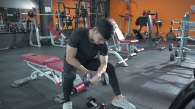 Fitness konsepti. Vücut geliştirici, spor salonunda halterlerle çalışıyor. 4k Çözünürlüğü.