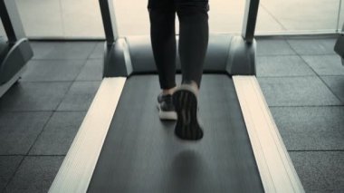 Fitness konsepti. Ayakları koşu bandında koşuyor. 4k Çözünürlüğü.