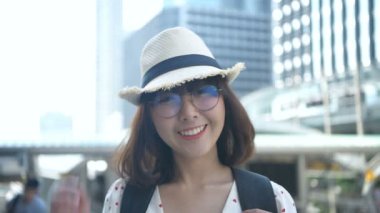 Tatil konsepti. Asyalı bir kadın şehrin içinde gülümsüyor. 4k Çözünürlüğü.