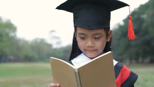 Conceitos Educacionais Uma Menina Vestindo Vestido Formatura Lendo Livro Jardim — Vídeo de Stock