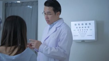 Optik dükkan konsepti. Göz doktoru, müşterinin gözlerini ölçüyor da. 4k Çözünürlüğü.