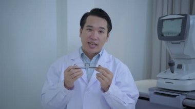 Optik dükkan konsepti. Göz doktoru gözlük seçimini açıklamaya çalışıyor. 4k Çözünürlüğü.